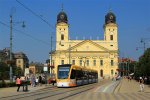 Wagon CAF Urbos3 numer 523 na linii 1 na tle kościoła przy placu Kossutha.